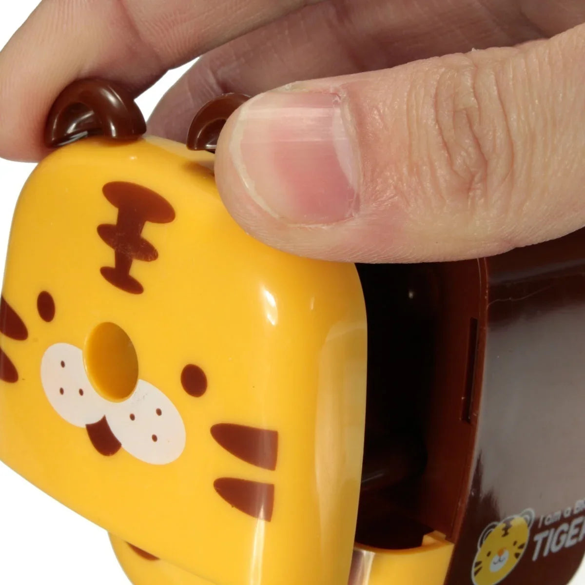 Hand inserting pencil into tiger animal pencil sharpener