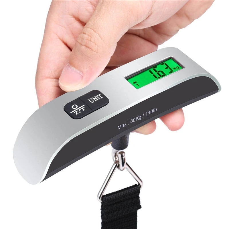 Hand holding digital luggage scale with backlit display