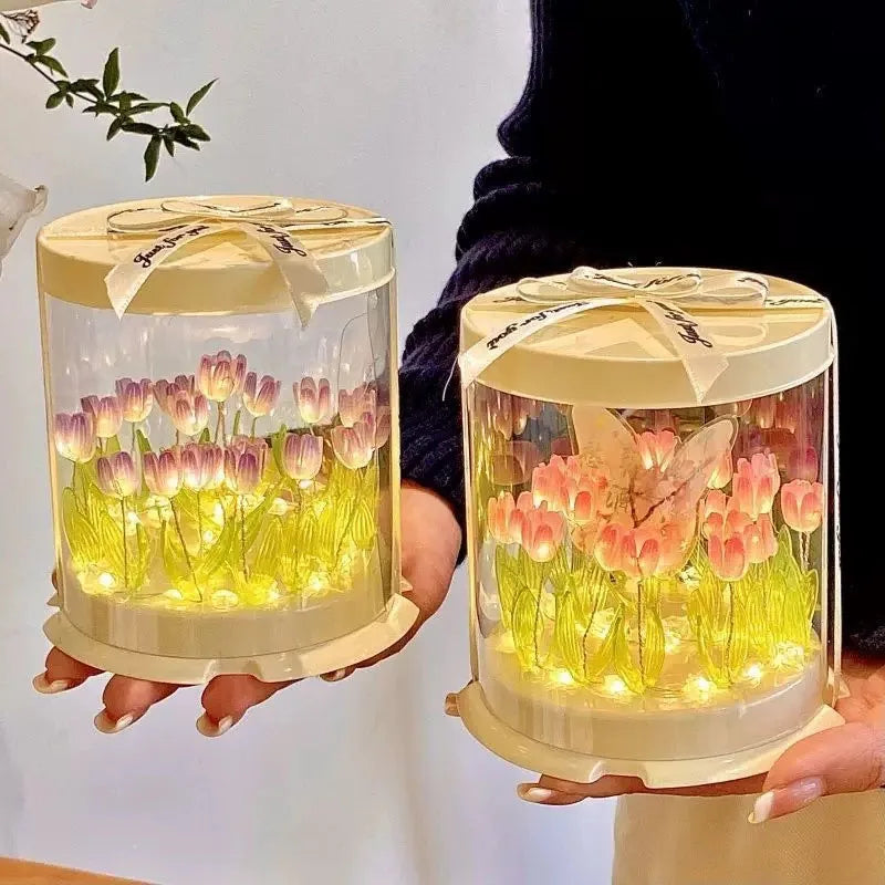 Tulip table lamp glowing pink and yellow held in hands