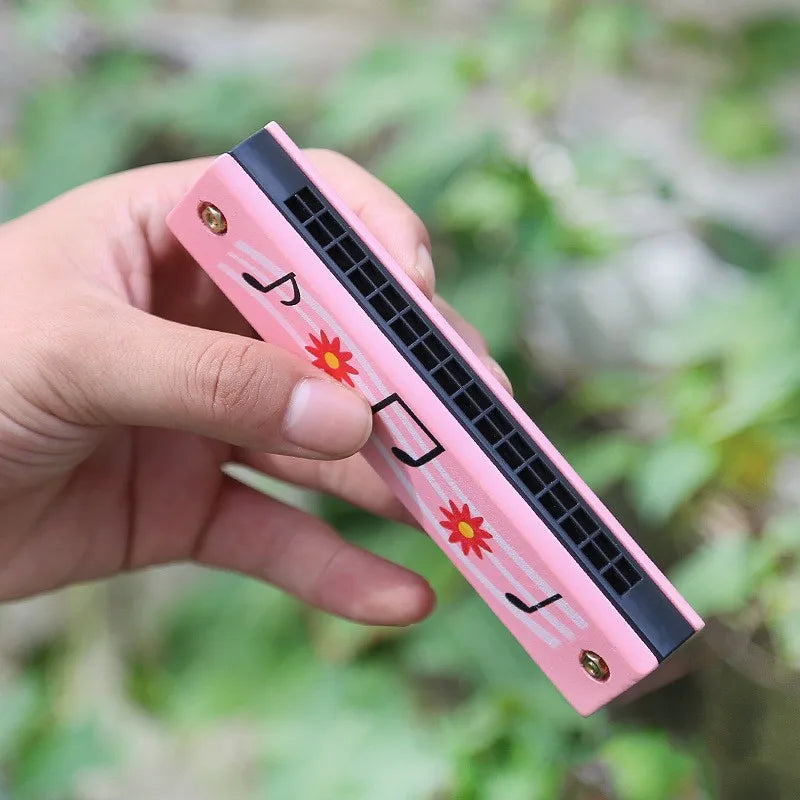 Wooden harmonica kids — hand holding pink notes harmonica