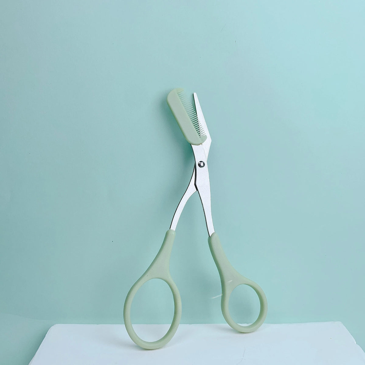 Brow grooming scissors with comb attachment