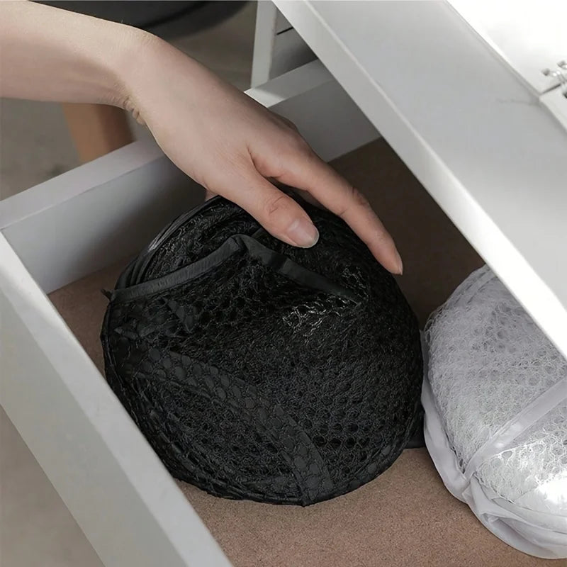 Collapsible laundry hamper folded flat and stored in a drawer
